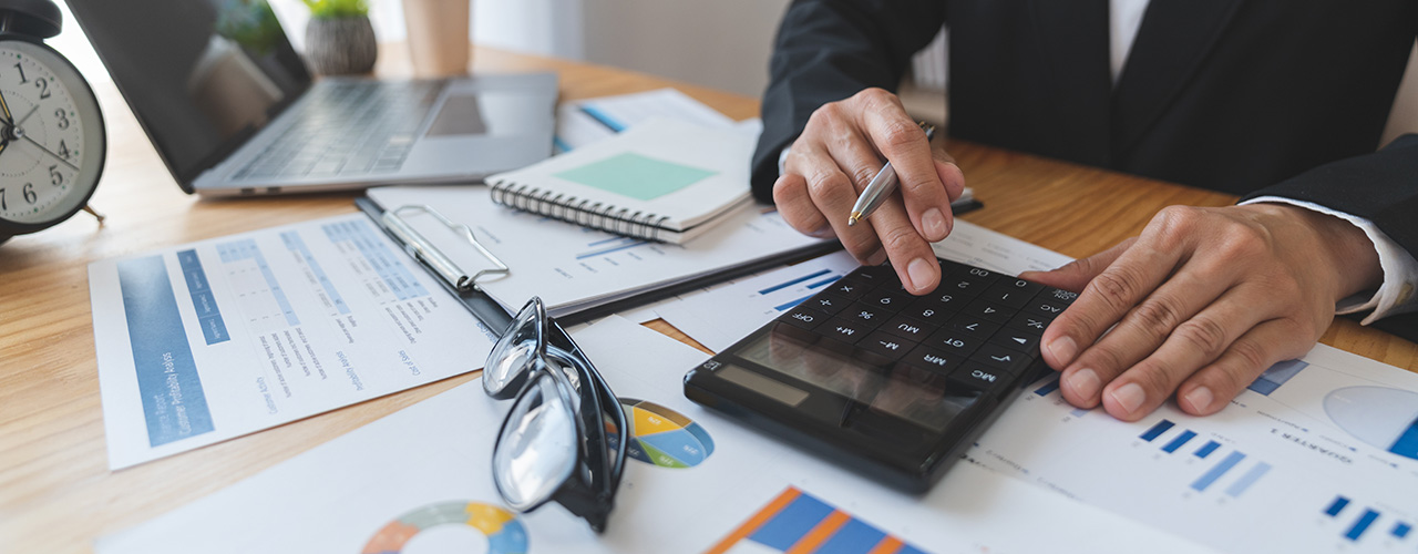 Geschäftsfrau berechnet den Umsatz mit Taschenrechner, Finanzberichte
