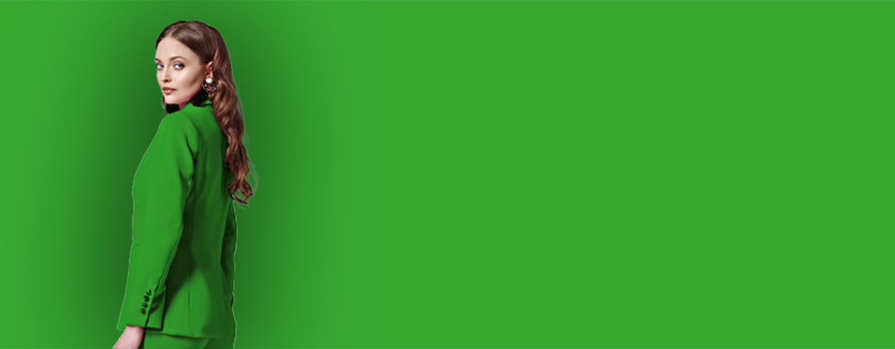 Dame in grünem Hosenanzug vor grünem Hintergrund