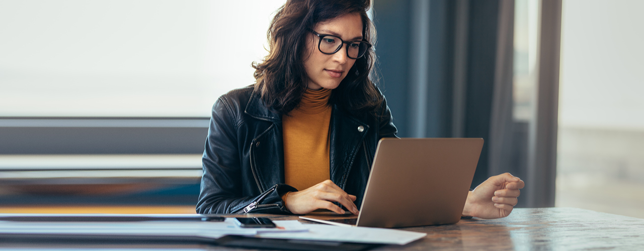 Eine junge Dame, die vor dem Laptop arbeitet