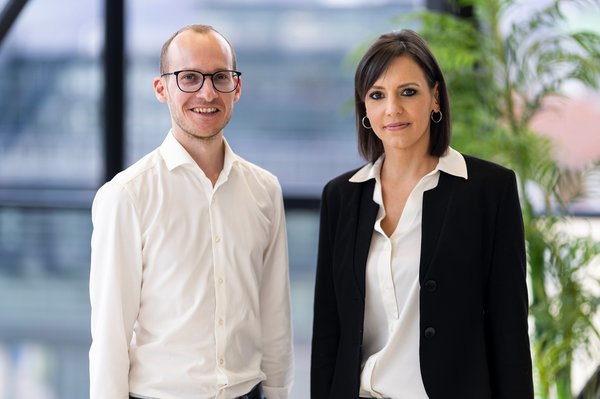 ein Mann und eine Frau vor einer Glaswand