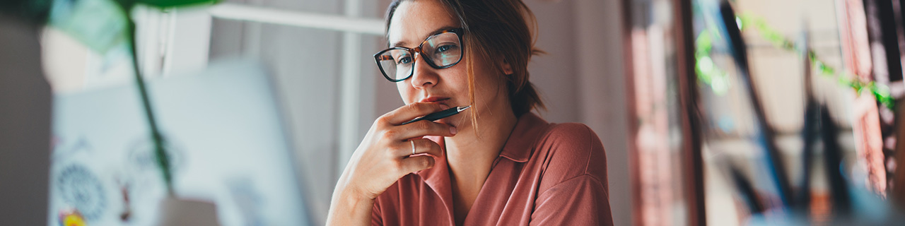 Mädchen mit Brille sitzt zu Hause vor Ihrem Laptop